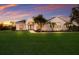 Beautiful single-story home featuring a manicured lawn, arched entryway, and lush landscaping at 8223 Snowy Egret Pl, Bradenton, FL 34202