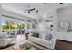Bright living room with white sofas and large windows overlooking the pool area at 8223 Snowy Egret Pl, Bradenton, FL 34202