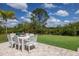Outdoor patio featuring a dining table, chairs, and a view of the expansive, well-maintained backyard at 8223 Snowy Egret Pl, Bradenton, FL 34202