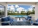 Inviting covered patio with comfortable seating overlooks a pristine pool and lush landscaping at 8223 Snowy Egret Pl, Bradenton, FL 34202
