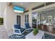 Covered patio with comfortable seating, outdoor TV, and seamless transition to the interior living space at 8223 Snowy Egret Pl, Bradenton, FL 34202