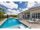 Backyard featuring a sparkling pool, hot tub, patio seating, and lush landscaping at 8223 Snowy Egret Pl, Bradenton, FL 34202
