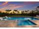 Inviting backyard pool with stylish lounge chairs and lush landscaping provides a private, resort-like experience at sunset at 8223 Snowy Egret Pl, Bradenton, FL 34202