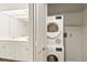 Well-organized laundry room with a stacked washer and dryer next to a vanity with drawers at 825 S Osprey Ave # 302, Sarasota, FL 34236