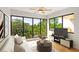 Staged living room with hardwood floors, large windows, and view of mature trees and a balcony at 825 S Osprey Ave # 302, Sarasota, FL 34236