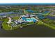 Aerial view of community with a resort-style pool and tennis courts overlooking a lake at 8313 Ocean Tides Cv, Parrish, FL 34219