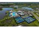 Aerial view of the pool and tennis courts overlooking a lake in a beautiful community at 8313 Ocean Tides Cv, Parrish, FL 34219