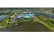 Aerial view of a resort-style pool, clubhouse, tennis courts, and surrounding lake at 8313 Ocean Tides Cv, Parrish, FL 34219