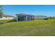 Expansive backyard featuring a covered patio, screened-in lanai, and lush lawn at 8313 Ocean Tides Cv, Parrish, FL 34219