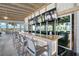 Modern outdoor bar features a light wood counter top, seating, and flat screen televisions at 8313 Ocean Tides Cv, Parrish, FL 34219