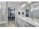 Bright bathroom featuring double sinks with marble countertops, and a view of the bedroom at 8313 Ocean Tides Cv, Parrish, FL 34219