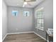 Well-lit bedroom featuring wood-look floors, a window, and a desk at 8313 Ocean Tides Cv, Parrish, FL 34219