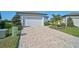 Paver driveway leading to a two-car garage with landscaped yard at 8313 Ocean Tides Cv, Parrish, FL 34219