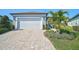 Paver driveway leading to a two-car garage with landscaped yard at 8313 Ocean Tides Cv, Parrish, FL 34219