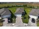 A manicured front yard with a paver driveway leading to a two-car garage, framed by mature landscaping at 8313 Ocean Tides Cv, Parrish, FL 34219