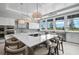 Modern kitchen featuring a large island with seating, stainless steel appliances, and ample natural light at 8313 Ocean Tides Cv, Parrish, FL 34219