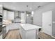 Bright kitchen with white cabinets, stainless steel appliances, an island, and stylish pendant lighting at 8313 Ocean Tides Cv, Parrish, FL 34219