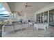 Relaxing outdoor lounge area with stylish white seating, ceiling fans, and open views at 8313 Ocean Tides Cv, Parrish, FL 34219