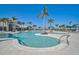 Resort-style pool featuring palm trees, lounge chairs, and clear blue water at 8313 Ocean Tides Cv, Parrish, FL 34219