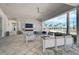 Covered poolside lounge with comfortable seating, fireplace, TV, and views of the pool and palm trees at 8313 Ocean Tides Cv, Parrish, FL 34219