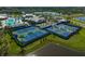Tennis courts beside a lake with lush landscaping and clear blue skies in a community at 8313 Ocean Tides Cv, Parrish, FL 34219