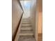 Staircase with neutral wood-look steps and wooden handrail at 940 Byron Ct # 17C, Sarasota, FL 34243