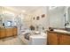 Bright bathroom featuring a tiled glass shower, soaking tub, and & sinks at 5356 Mang Pl # 1404, Sarasota, FL 34238