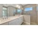 Bathroom featuring double sink vanity, large frameless mirror, and walk-in shower with tiled walls and window at 10027 Cross River Trl, Parrish, FL 34219