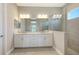 Modern bathroom featuring double sink vanity, large mirrors, tiled shower with glass and neutral tiling at 10027 Cross River Trl, Parrish, FL 34219