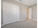 Bright bedroom with white bi-fold closet doors, neutral walls, grey carpet flooring, and natural light at 10027 Cross River Trl, Parrish, FL 34219