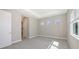 Bright bedroom featuring neutral walls, carpet floors, tray ceilings and natural light with three small square windows at 10027 Cross River Trl, Parrish, FL 34219