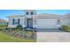 Charming single-Gathering home featuring a paved driveway, two-car garage, and well-manicured lawn at 10027 Cross River Trl, Parrish, FL 34219
