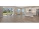 Open living area with wood-look floors, sliding glass doors, and a modern kitchen at 10027 Cross River Trl, Parrish, FL 34219