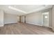 Large open space with wood-look floors, tray ceiling, and access to multiple rooms at 10027 Cross River Trl, Parrish, FL 34219