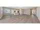 Bright living area with wood-look floors, leading into a white kitchen with stainless steel appliances at 10027 Cross River Trl, Parrish, FL 34219