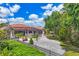 Beautifully landscaped backyard featuring a screened-in patio, decorative rock garden, and mature trees at 11551 30Th E Cv, Parrish, FL 34219
