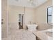 Luxurious bathroom with a standalone soaking tub, tiled flooring, and elegant fixtures at 11551 30Th E Cv, Parrish, FL 34219