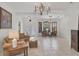 Spacious living room with tile flooring, decorative chandelier and ornate front door at 11551 30Th E Cv, Parrish, FL 34219