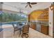 Outdoor kitchen and dining area adjacent to screened-in pool, ideal for entertaining at 11551 30Th E Cv, Parrish, FL 34219
