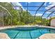 Inviting screened-in pool area with lush landscaping, creating a private and refreshing outdoor space at 11551 30Th E Cv, Parrish, FL 34219