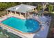 Aerial view of community pool with lounge chairs, awning and landscaped surroundings at 11551 30Th E Cv, Parrish, FL 34219