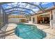 Inviting screened-in pool area with brick pavers, outdoor kitchen, and comfortable seating at 11551 30Th E Cv, Parrish, FL 34219