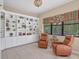 Cozy sitting room with custom built-in shelving, comfortable seating, and a peaceful view of the outdoors at 11551 30Th E Cv, Parrish, FL 34219