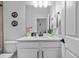 Well-lit bathroom with modern fixtures, a white vanity, and decorative wall art at 11719 Chevelon Ln, Parrish, FL 34219