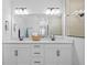 Elegant bathroom with double sinks, granite counters, and a basket with fresh towels at 11719 Chevelon Ln, Parrish, FL 34219