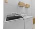 Well-equipped laundry room with modern washer and dryer, plus overhead storage at 11719 Chevelon Ln, Parrish, FL 34219