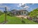 Charming backyard features a brick patio, birdhouses, and lush landscaping, creating a serene outdoor oasis at 13130 50Th E Ct, Parrish, FL 34219