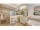 Bright bathroom featuring walk-in shower, soaking tub, vanity with sink, and stylish tile flooring at 13130 50Th E Ct, Parrish, FL 34219