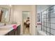 Elegant bathroom features black vanity, patterned tile floor, and glass enclosed shower at 13130 50Th E Ct, Parrish, FL 34219