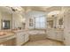 Bathroom featuring dual sinks, vanity, soaking tub, and a large window for natural light at 13130 50Th E Ct, Parrish, FL 34219